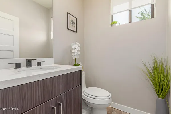a bathroom with a sink mirror vanity and toilet