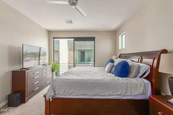 a bedroom with a large bed and large windows