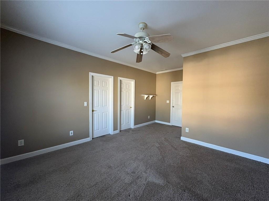 5930 Abbotts Run Trail Duluth, GA 30097 - Photo 24 of 32 a view of a room with a ceiling fan and carpet