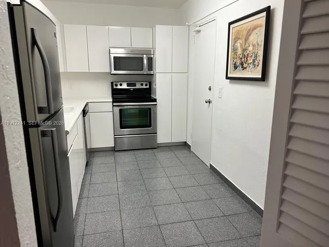 a kitchen with stainless steel appliances a refrigerator and a stove top oven
