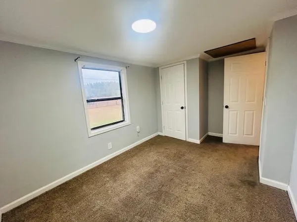 an empty room with windows and closet