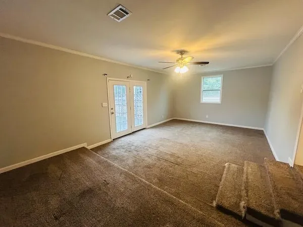 en empty room with windows and ceiling fan view