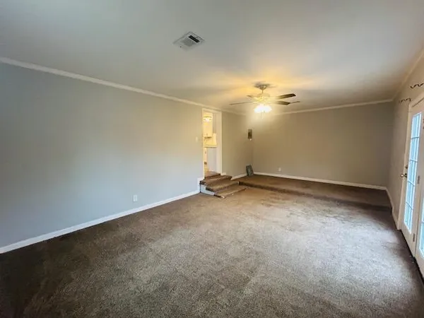an empty room with a ceiling fan and window