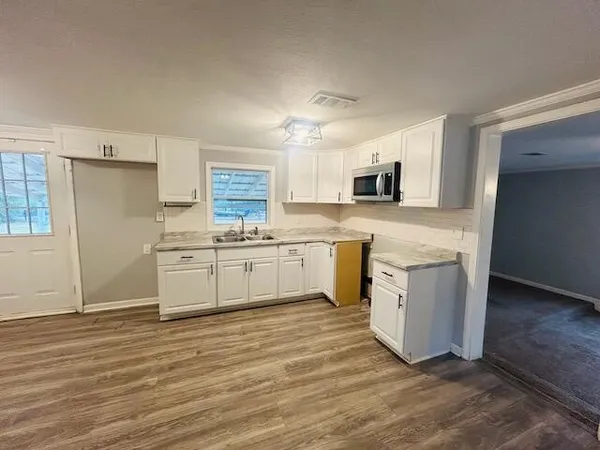 a kitchen with white cabinets and white appliances