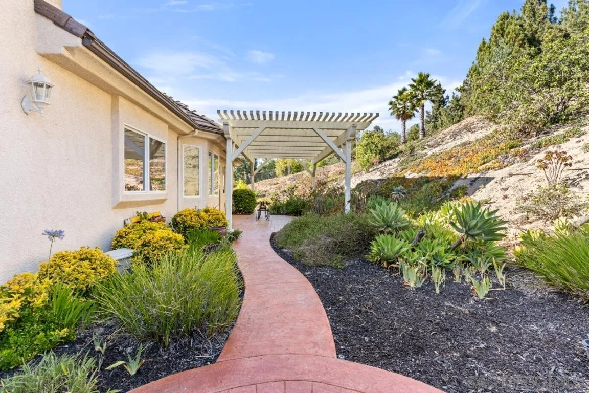 246 Yucca Road Fallbrook, CA 92028 - Photo 54 of 68 a front view of a house with a yard and potted plants