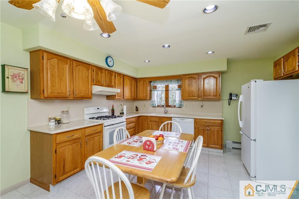 17 Garden Street East Hanover, NJ 07936 - Photo 8 of 34 a kitchen with a refrigerator a stove a sink dishwasher with a dining table and chairs