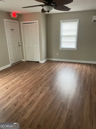 an empty room with wooden floor and windows
