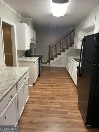 a large kitchen with granite countertop a large counter top space and stainless steel appliances