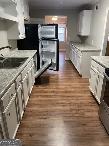 a kitchen with granite countertop a sink stove and refrigerator