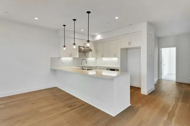 a view of a kitchen with a sink and large window