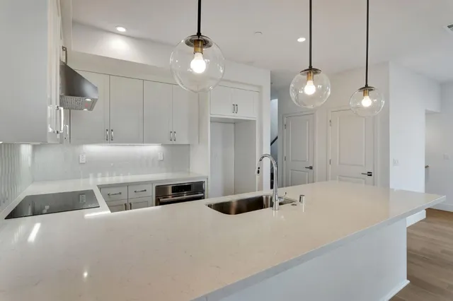 a kitchen with stainless steel appliances granite countertop a sink a stove and a refrigerator