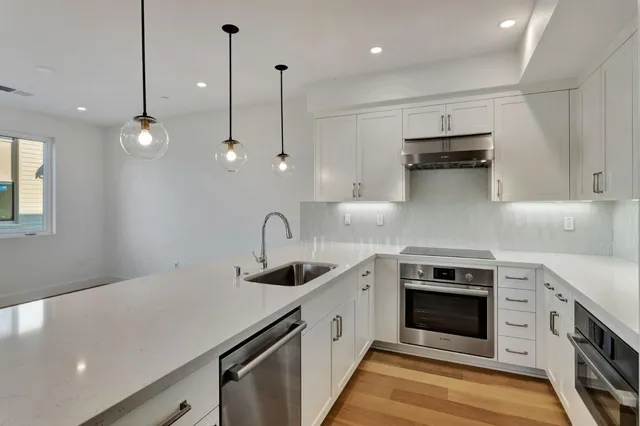 a kitchen with a sink a counter space and a chandelier