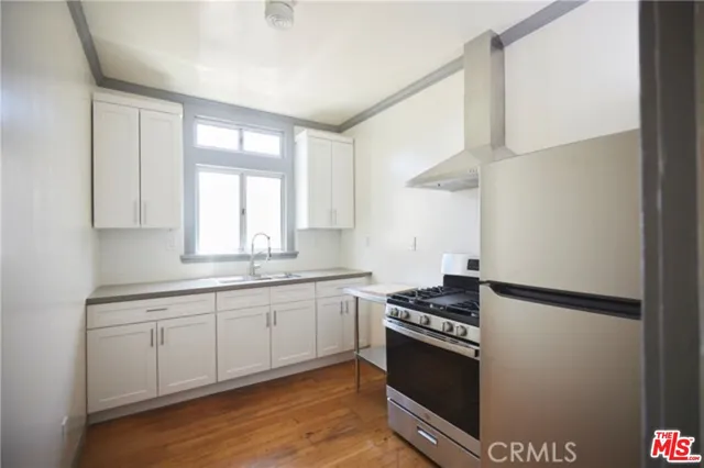 a kitchen with stainless steel appliances granite countertop a sink a stove and a refrigerator