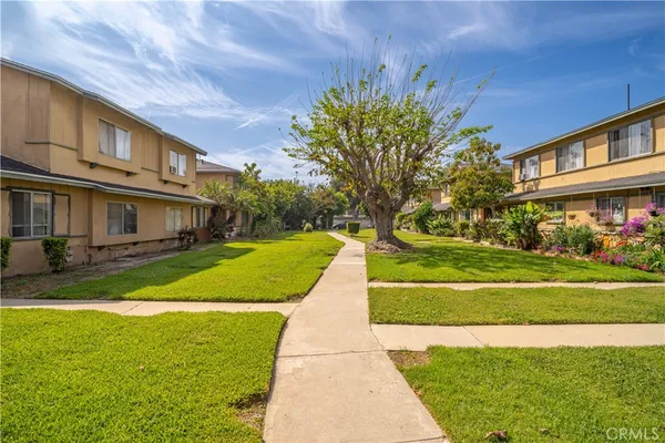 a view of a house with a big yard plants and large trees