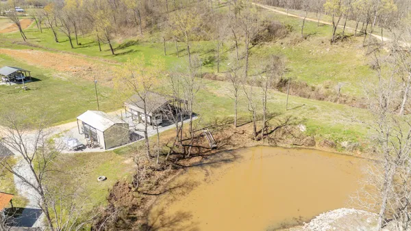 a view of swimming pool with lawn chairs and iron fence