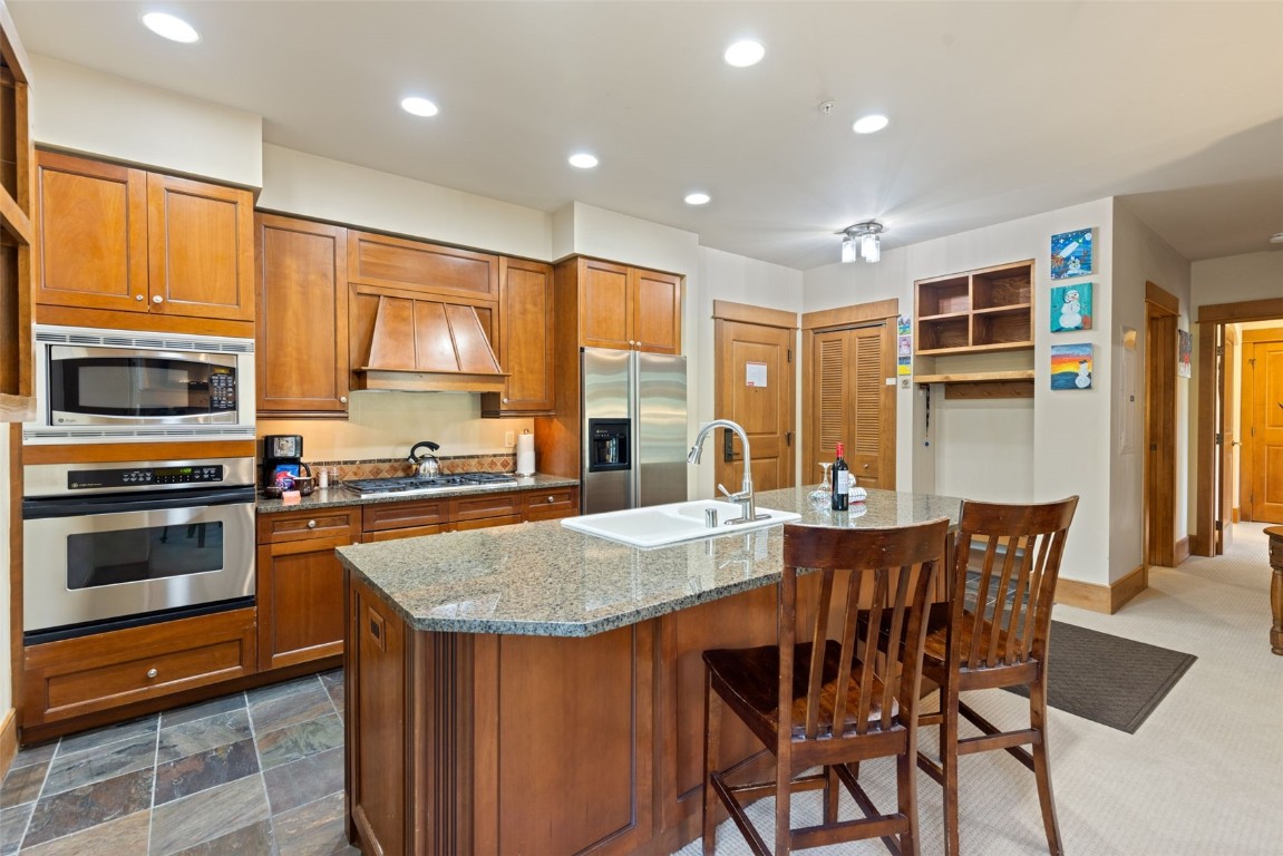 280 Trailhead Drive, Unit 3027 Keystone, CO 80435 - Photo 15 of 50 a kitchen with stainless steel appliances granite countertop a stove top oven a sink a dining table and chairs