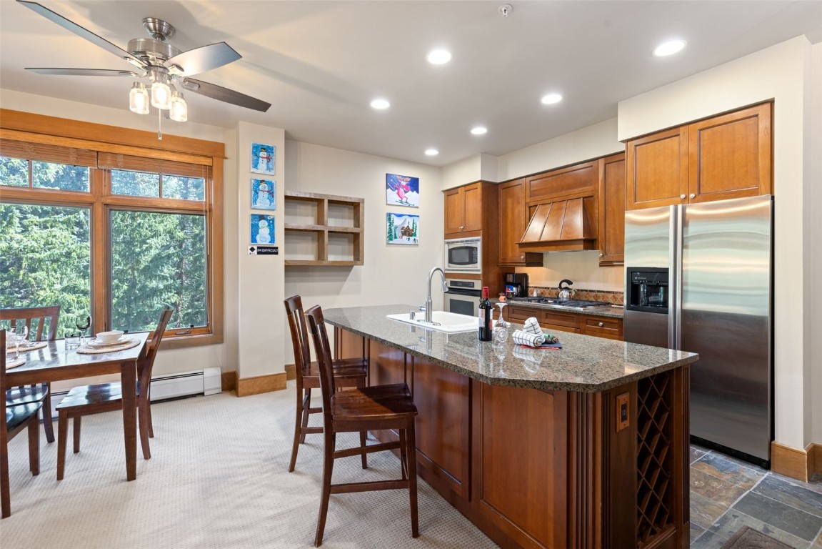 280 Trailhead Drive, Unit 3027 Keystone, CO 80435 - Photo 16 of 50 a kitchen with stainless steel appliances granite countertop a table chairs and a refrigerator