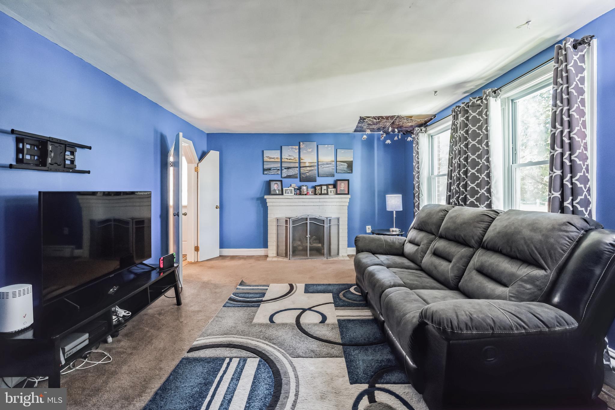 1443 Rhawn Street Philadelphia, PA 19111 - Photo 4 of 45 a living room with furniture a flat screen tv and a fireplace