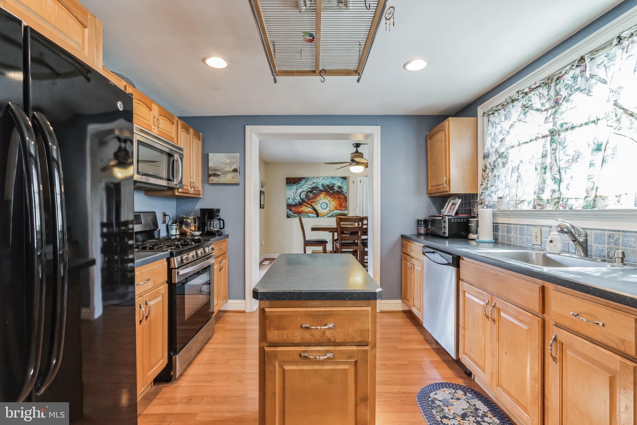 1443 Rhawn Street Philadelphia, PA 19111 - Photo 10 of 45 a large kitchen with stainless steel appliances granite countertop a stove a refrigerator a sink dishwasher and wooden cabinets with wooden floor
