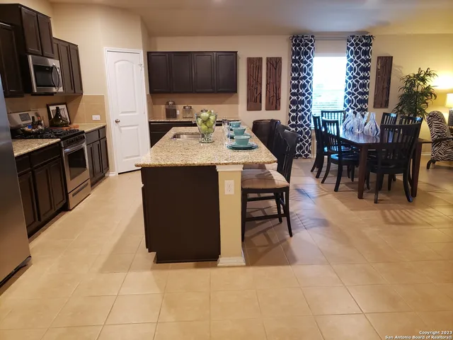 a kitchen with stainless steel appliances kitchen island granite countertop a sink a counter top space and cabinets