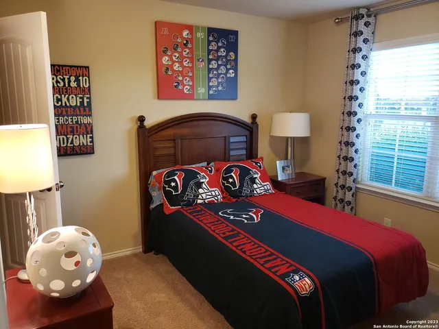 a bedroom with a bed and a lamp next to a window