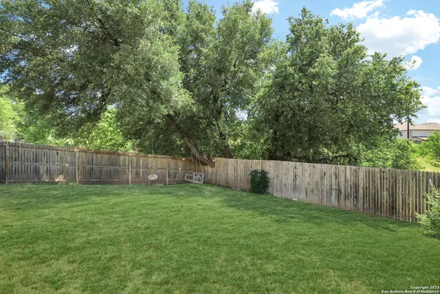 a view of a yard with wooden fence