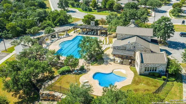 an aerial view of a house with swimming pool a patio and yard