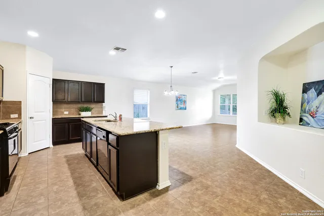 a kitchen with stainless steel appliances kitchen island granite countertop a stove top oven and sink
