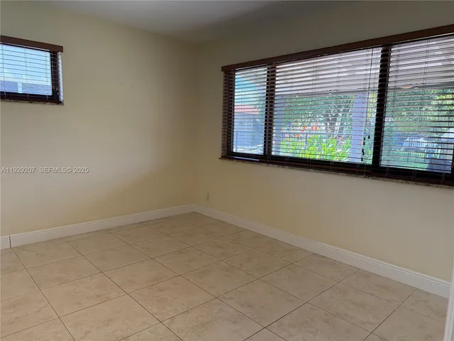an empty room with a ceiling fan and a window