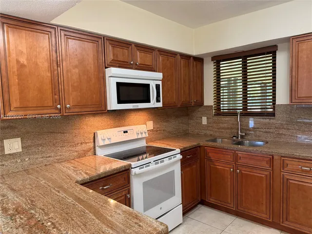 a kitchen with stainless steel appliances granite countertop a sink stove and microwave