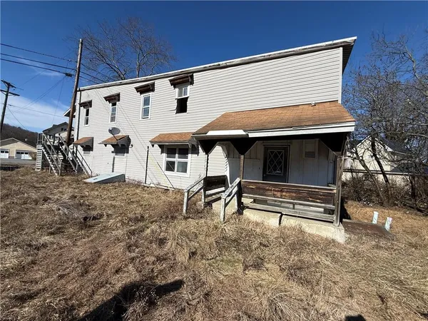 a view of house with backyard and furniture