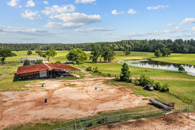 a white house with a big yard and large trees