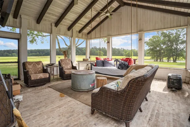 a living room with furniture a fireplace and a floor to ceiling window