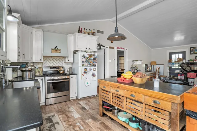 a kitchen with stainless steel appliances a stove a sink and a dining table