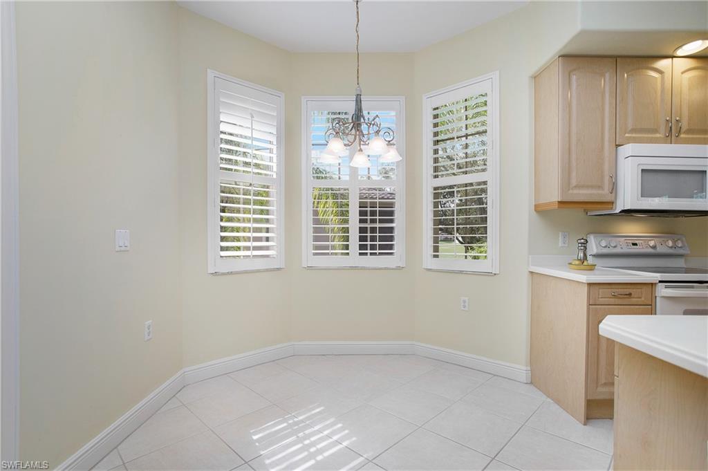 758 Regency Reserve Circle, Unit 2103 Naples, FL 34119 - Photo 11 of 41 a kitchen with granite countertop a stove a sink and a window