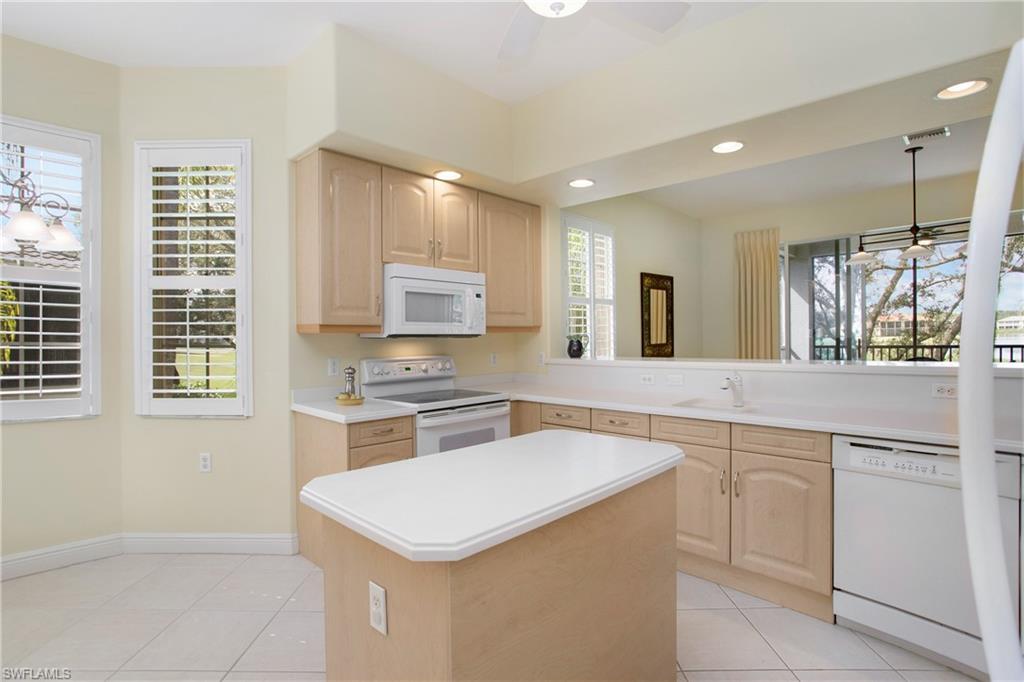 758 Regency Reserve Circle, Unit 2103 Naples, FL 34119 - Photo 12 of 41 a kitchen with cabinets appliances a sink and a window