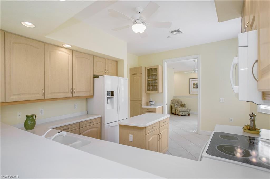 758 Regency Reserve Circle, Unit 2103 Naples, FL 34119 - Photo 13 of 41 a kitchen with stainless steel appliances granite countertop a sink and a refrigerator