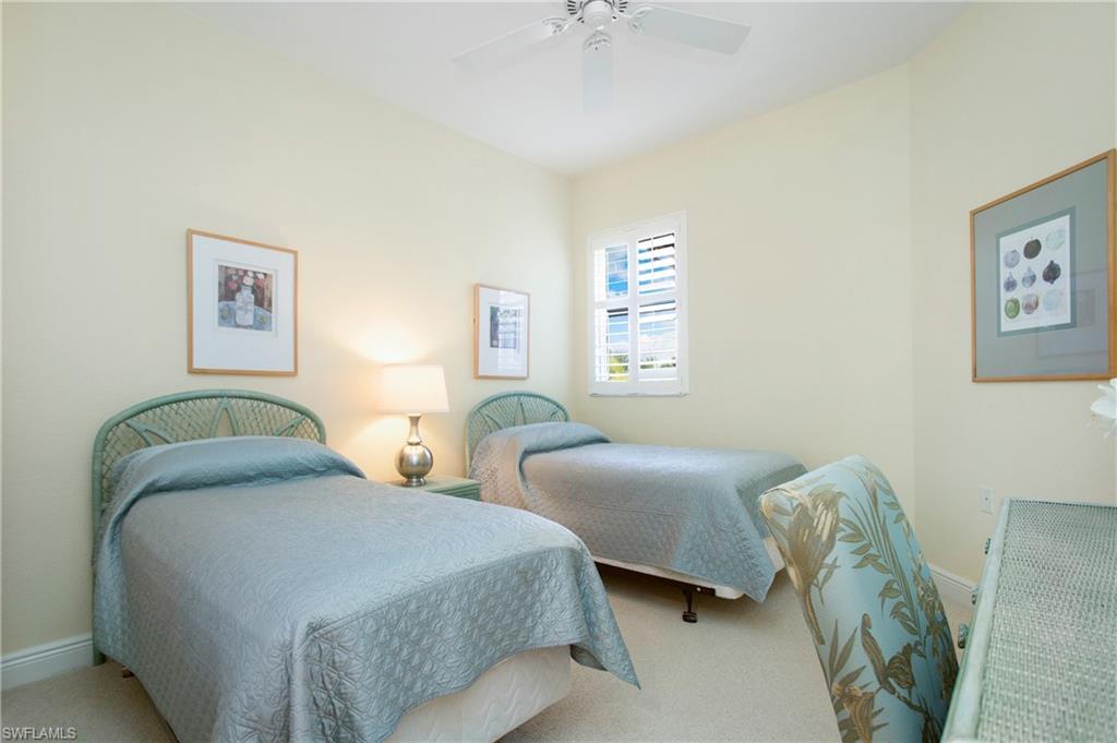 758 Regency Reserve Circle, Unit 2103 Naples, FL 34119 - Photo 14 of 41 a bedroom with two beds and a window