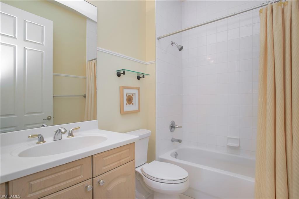 758 Regency Reserve Circle, Unit 2103 Naples, FL 34119 - Photo 16 of 41 a bathroom with a granite countertop sink a toilet and shower