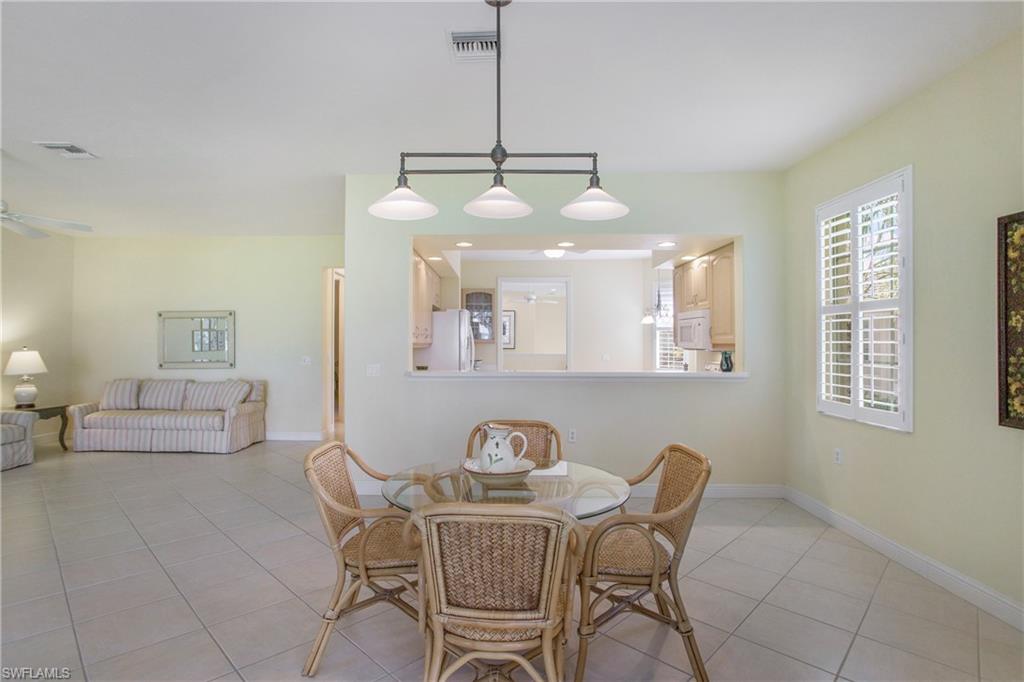 758 Regency Reserve Circle, Unit 2103 Naples, FL 34119 - Photo 22 of 41 a view of a dining room with furniture and chandelier