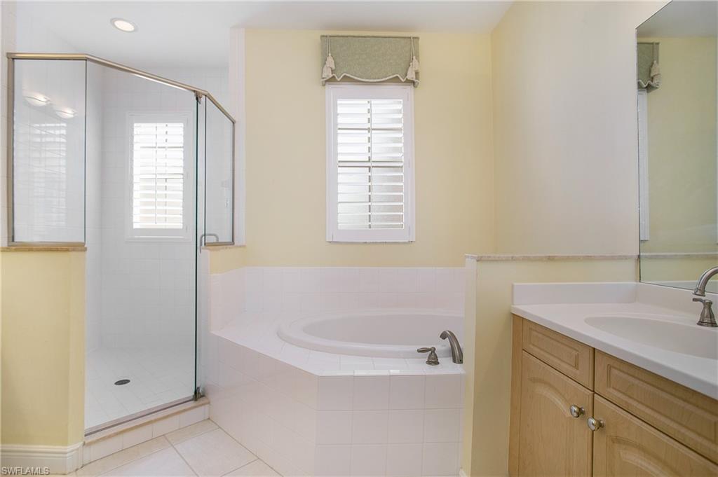 758 Regency Reserve Circle, Unit 2103 Naples, FL 34119 - Photo 28 of 41 a white bath tub sitting next to a white sink