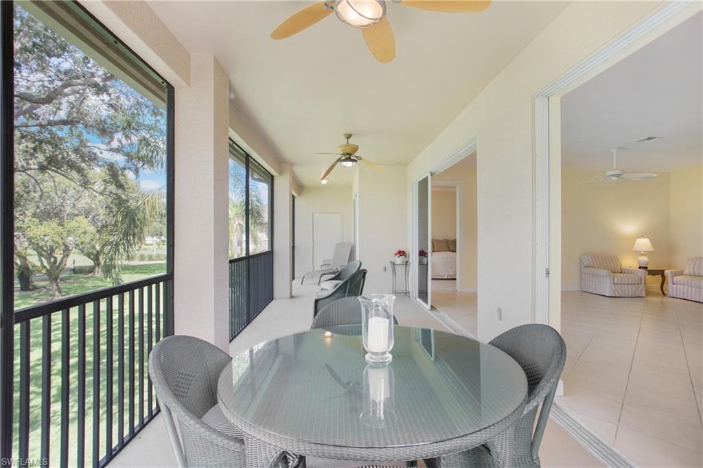 758 Regency Reserve Circle, Unit 2103 Naples, FL 34119 - Photo 36 of 41 a dining room with wooden floor a chandelier a glass table and chairs
