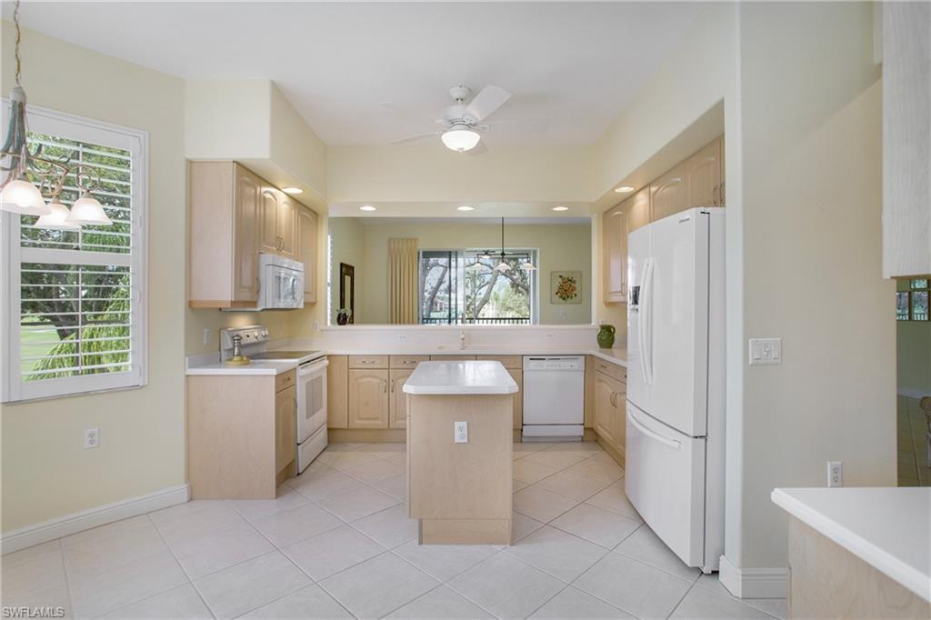 758 Regency Reserve Circle, Unit 2103 Naples, FL 34119 - Photo 9 of 41 a kitchen with a refrigerator and a sink