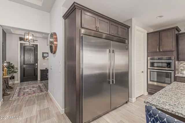 a kitchen with granite countertop a table chairs stainless steel appliances and wooden floor