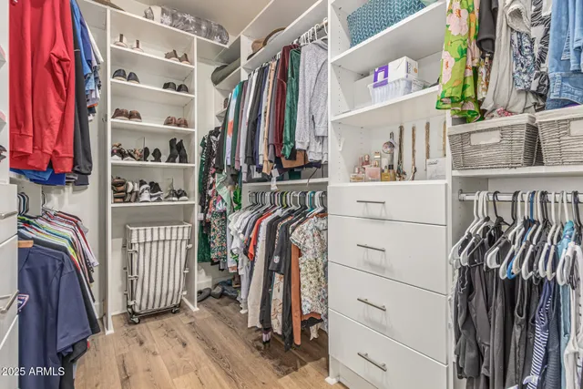 a view of walk in closet with clothes and shoes