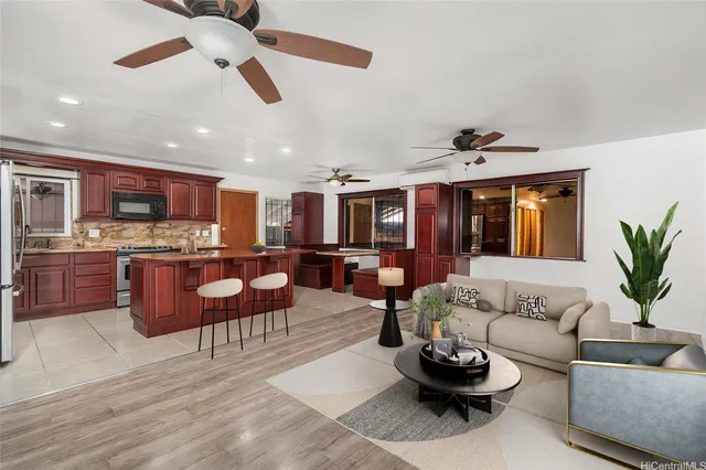 a living room with furniture kitchen view and a chandelier