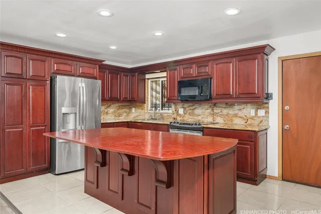 a kitchen with stainless steel appliances granite countertop wooden cabinets a refrigerator and a sink