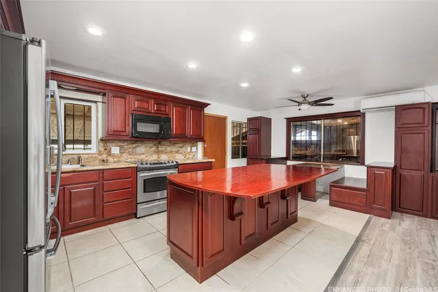 a large kitchen with stainless steel appliances granite countertop a large stove a sink dishwasher and cabinets with wooden floor