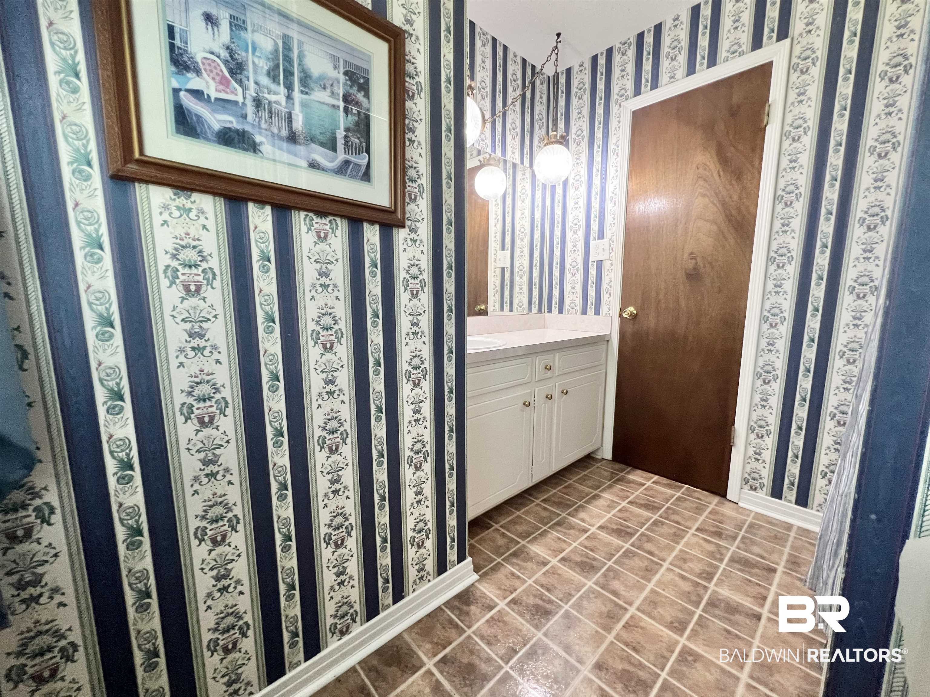 2691 Appleton Road Brewton, AL 36426 - Photo 43 of 60 Half bath with wallpapered walls, vanity, and tile patterned floors