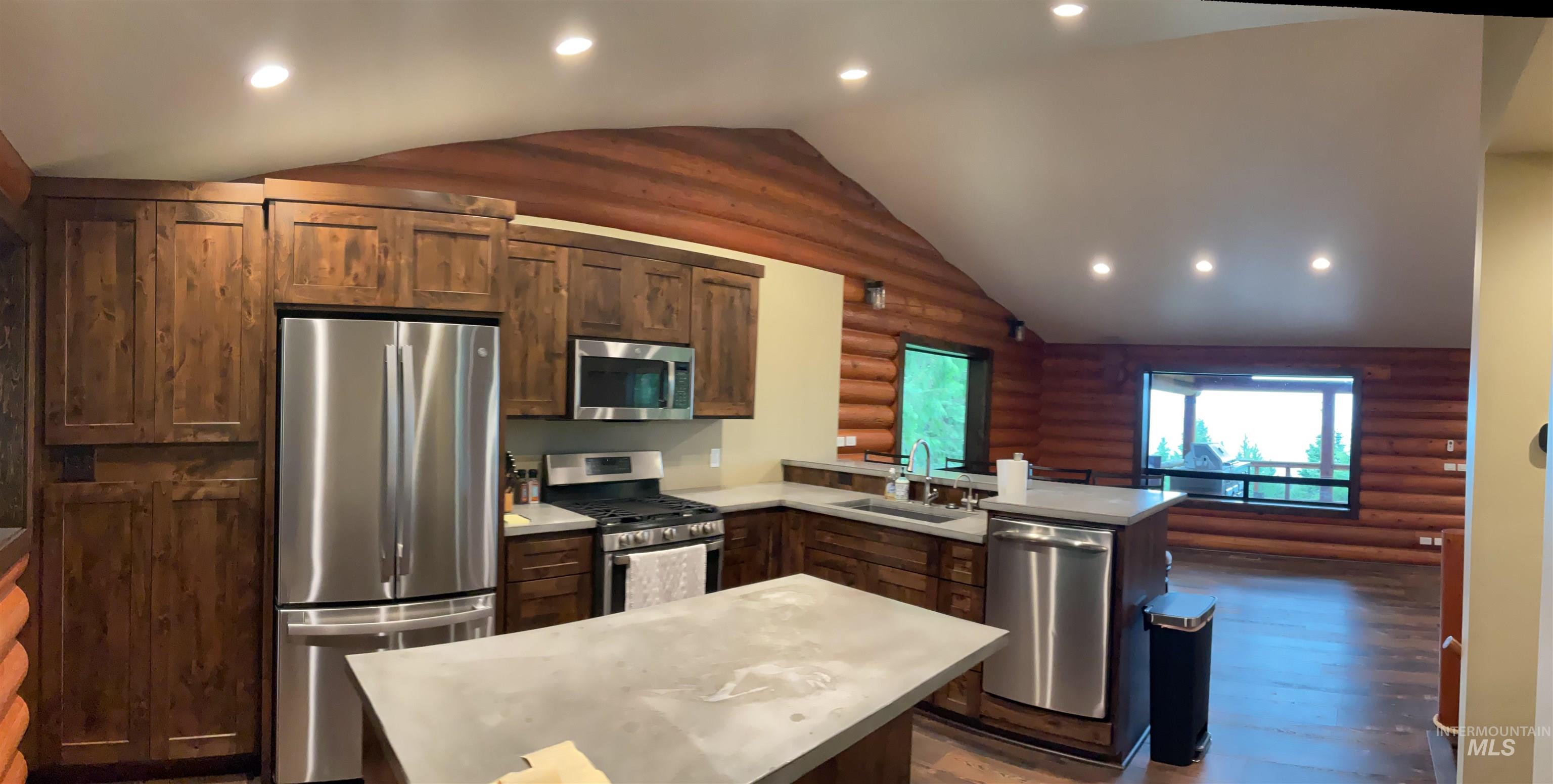 6125 Freeman Creek Road Lenore, ID 83541 - Photo 7 of 44 Kitchen featuring stainless steel appliances, wood-finish cabinetry, and solid surface countertops with an integrated sink